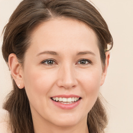 Joyful white young-adult female with long  brown hair and brown eyes