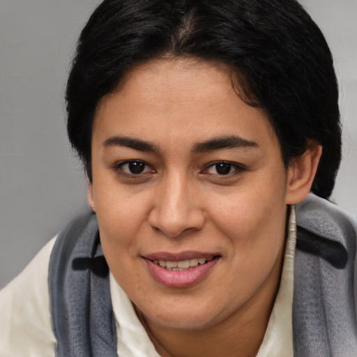 Joyful latino young-adult female with short  brown hair and brown eyes