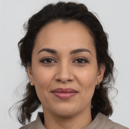 Joyful latino young-adult female with medium  brown hair and brown eyes