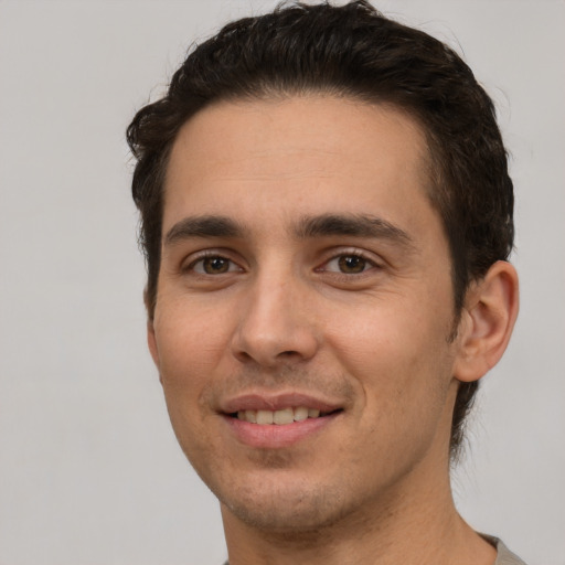 Joyful white young-adult male with short  brown hair and brown eyes