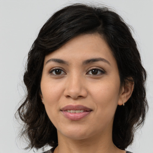 Joyful latino young-adult female with medium  brown hair and brown eyes