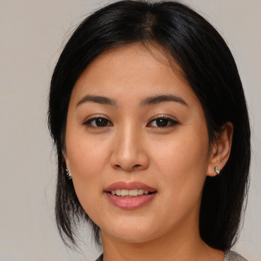 Joyful asian young-adult female with medium  brown hair and brown eyes