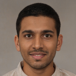 Joyful latino young-adult male with short  brown hair and brown eyes