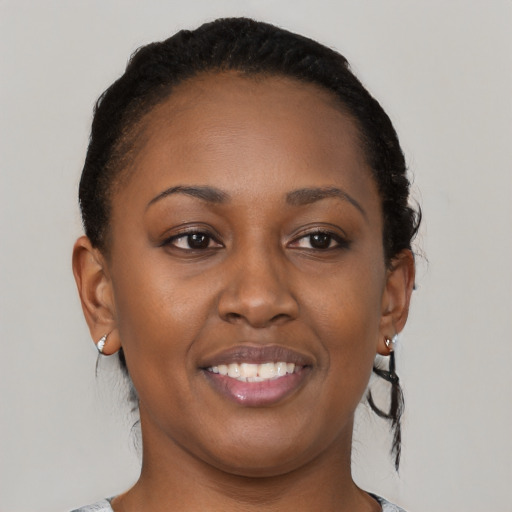 Joyful black young-adult female with short  brown hair and brown eyes