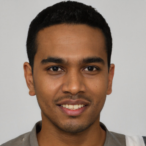 Joyful black young-adult male with short  black hair and brown eyes
