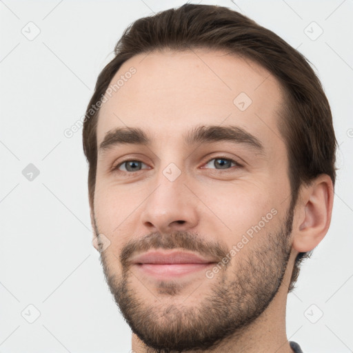 Joyful white young-adult male with short  brown hair and grey eyes