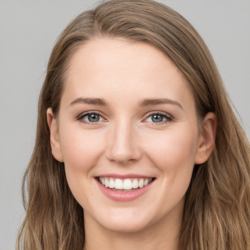 Joyful white young-adult female with long  brown hair and grey eyes