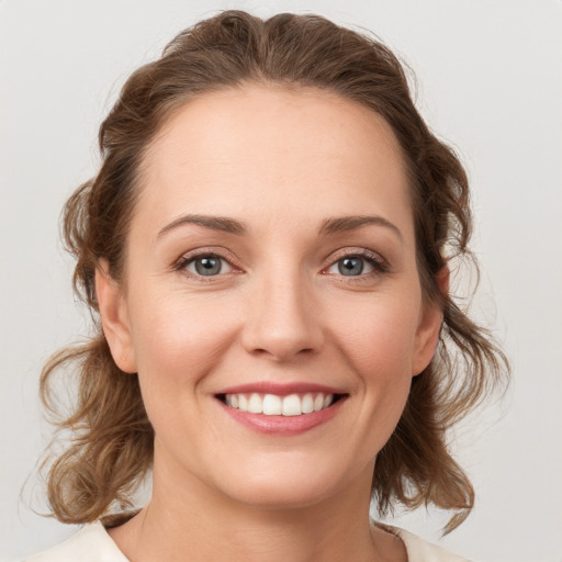 Joyful white young-adult female with medium  brown hair and green eyes