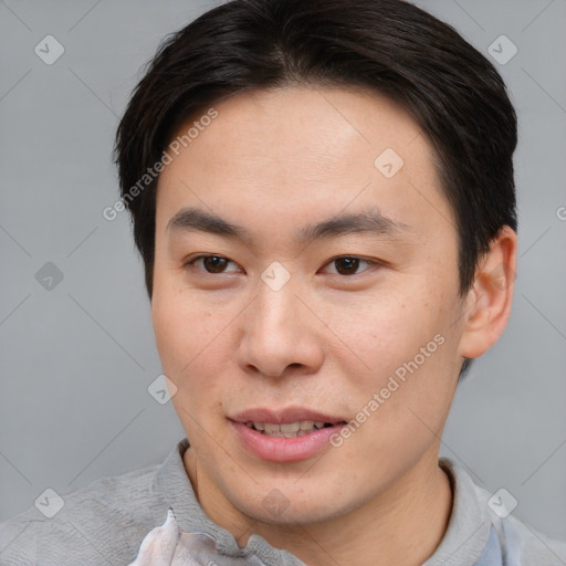 Joyful asian young-adult male with short  brown hair and brown eyes