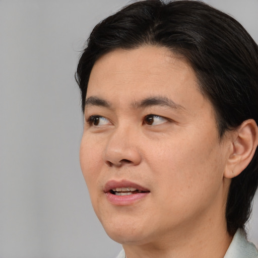 Joyful asian adult male with medium  brown hair and brown eyes