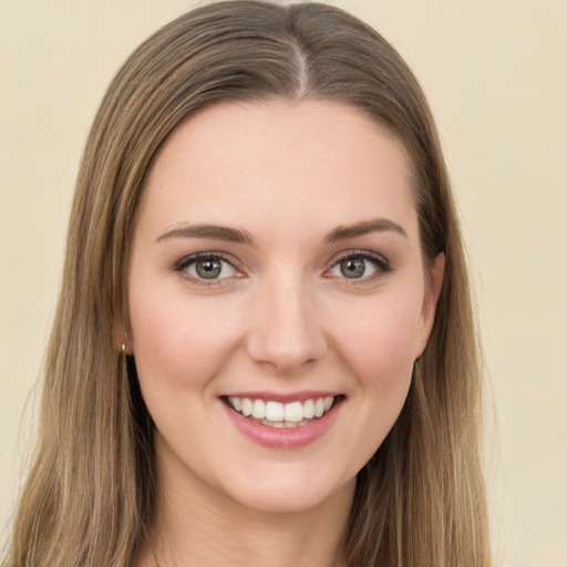 Joyful white young-adult female with long  brown hair and green eyes