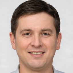 Joyful white young-adult male with short  brown hair and brown eyes