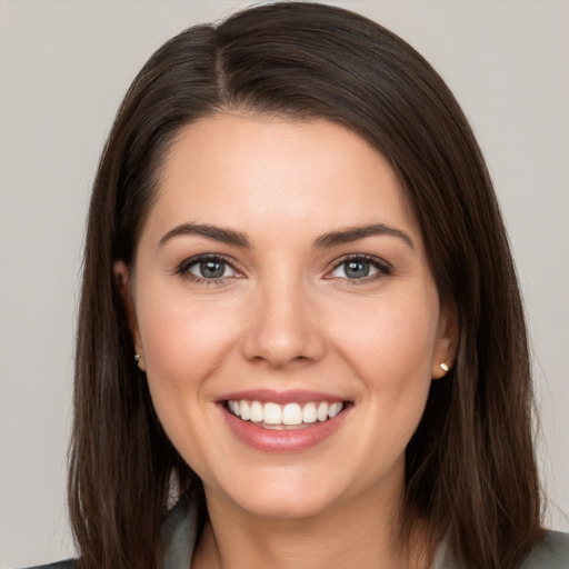 Joyful white young-adult female with long  brown hair and brown eyes