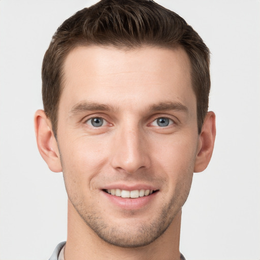 Joyful white young-adult male with short  brown hair and grey eyes