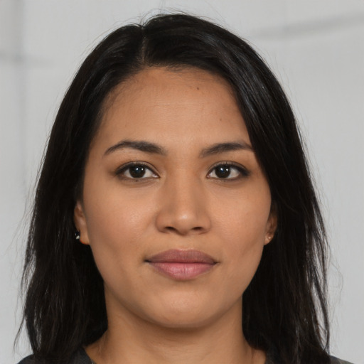Joyful latino young-adult female with long  black hair and brown eyes