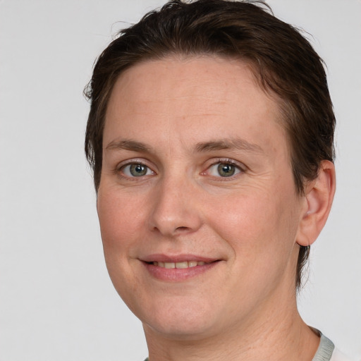 Joyful white adult female with short  brown hair and grey eyes