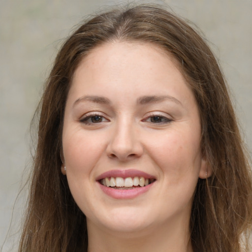 Joyful white young-adult female with long  brown hair and grey eyes