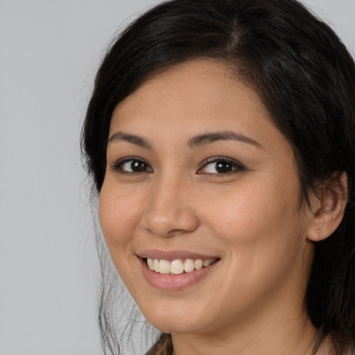 Joyful white young-adult female with long  brown hair and brown eyes