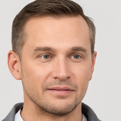 Joyful white young-adult male with short  brown hair and grey eyes