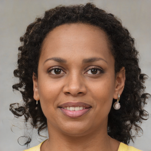 Joyful black young-adult female with medium  brown hair and brown eyes