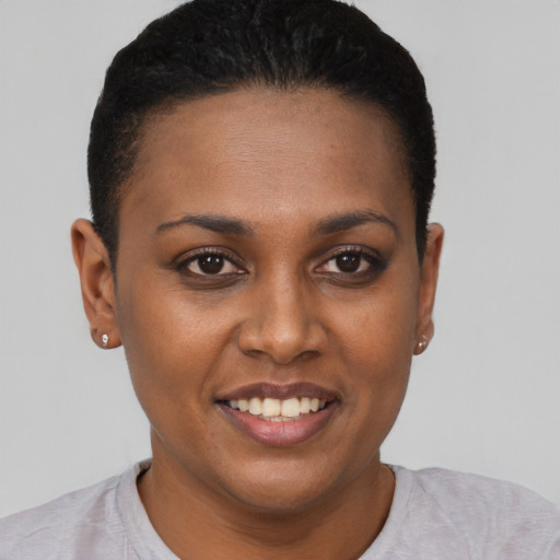 Joyful black young-adult female with short  black hair and brown eyes