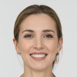 Joyful white young-adult female with medium  brown hair and grey eyes