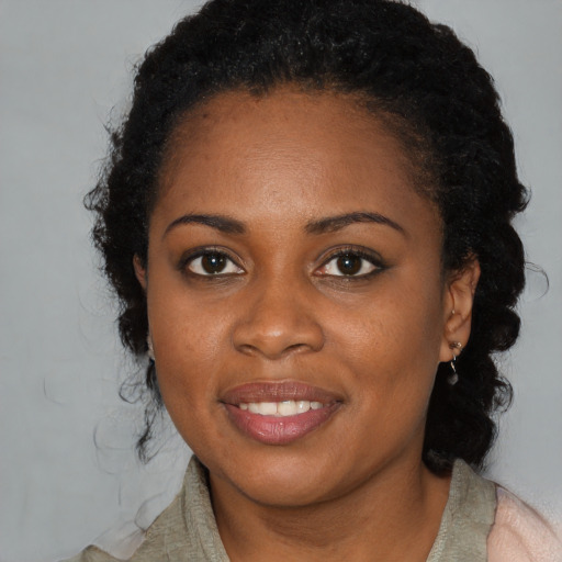 Joyful black young-adult female with medium  black hair and brown eyes