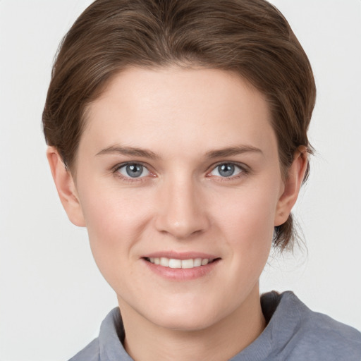 Joyful white young-adult female with short  brown hair and grey eyes