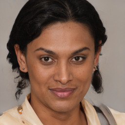 Joyful latino adult female with medium  brown hair and brown eyes