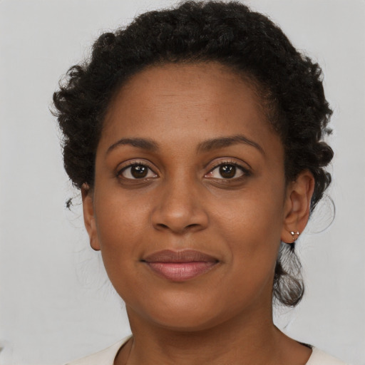 Joyful black young-adult female with short  brown hair and brown eyes