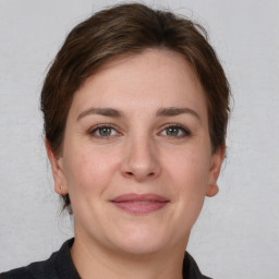 Joyful white young-adult female with medium  brown hair and grey eyes