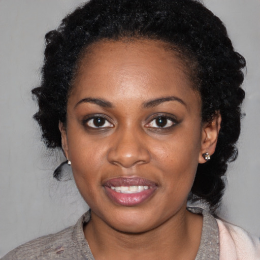 Joyful black young-adult female with medium  black hair and brown eyes
