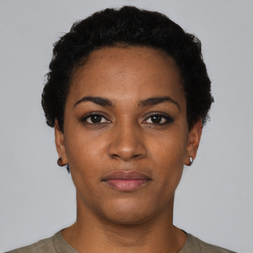Joyful black young-adult female with short  black hair and brown eyes