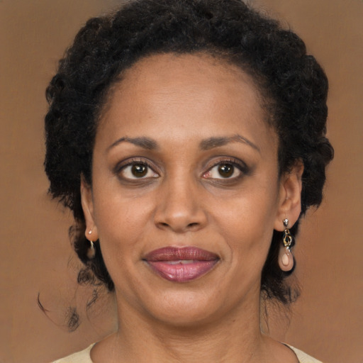 Joyful black adult female with long  brown hair and brown eyes
