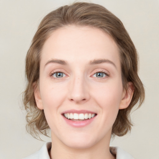 Joyful white young-adult female with medium  brown hair and green eyes