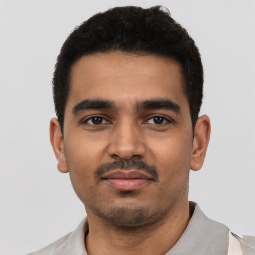 Joyful latino young-adult male with short  black hair and brown eyes