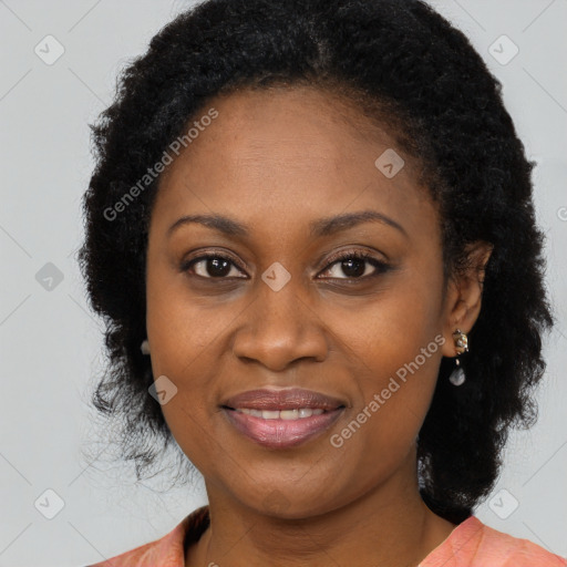 Joyful black adult female with long  brown hair and brown eyes