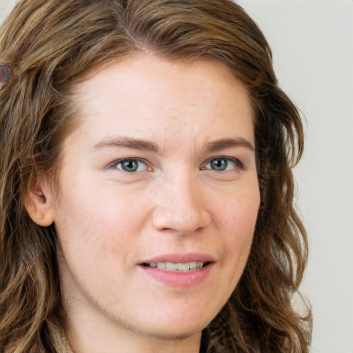 Joyful white young-adult female with long  brown hair and blue eyes