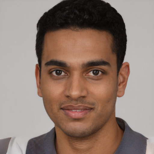 Joyful black young-adult male with short  black hair and brown eyes