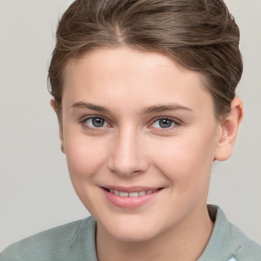 Joyful white young-adult female with short  brown hair and grey eyes