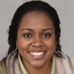 Joyful black young-adult female with long  brown hair and brown eyes