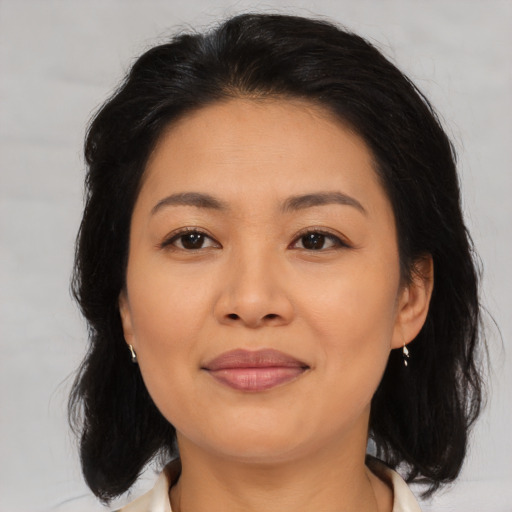 Joyful asian adult female with medium  brown hair and brown eyes