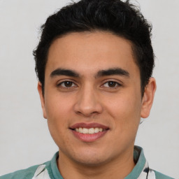 Joyful latino young-adult male with short  brown hair and brown eyes