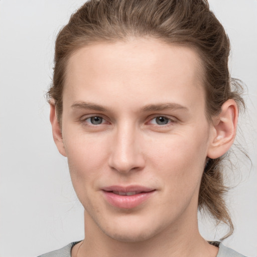 Joyful white young-adult female with short  brown hair and grey eyes