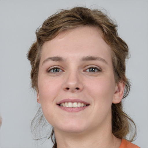 Joyful white young-adult female with medium  brown hair and blue eyes