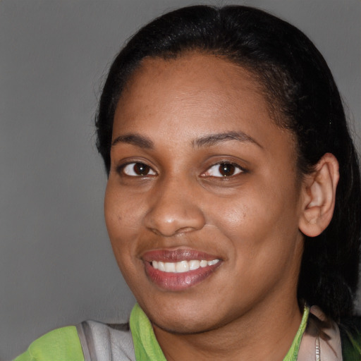 Joyful black young-adult female with short  black hair and brown eyes
