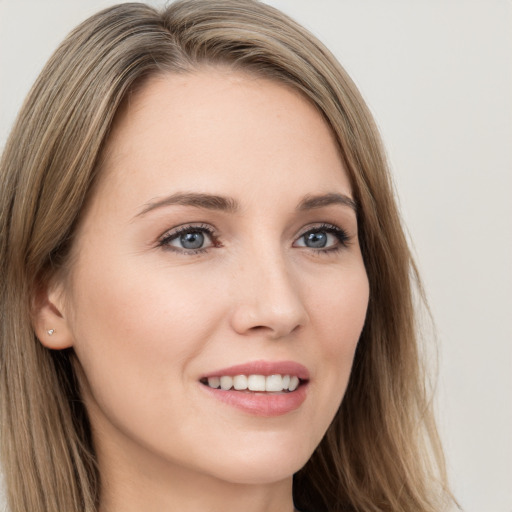 Joyful white young-adult female with long  brown hair and brown eyes