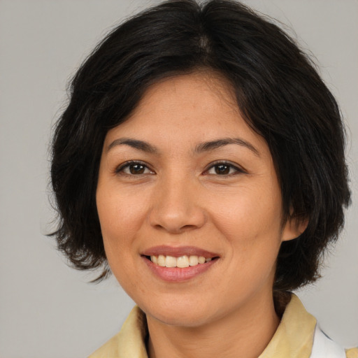 Joyful asian adult female with medium  brown hair and brown eyes