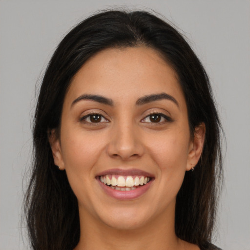 Joyful latino young-adult female with long  brown hair and brown eyes