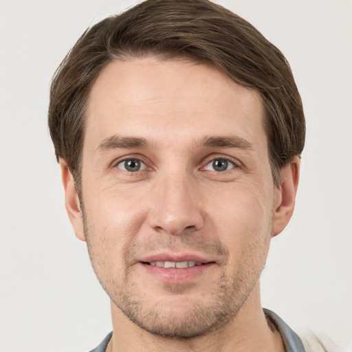 Joyful white young-adult male with short  brown hair and grey eyes